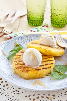 Grilled pineapple rings with ice cream balls and honey