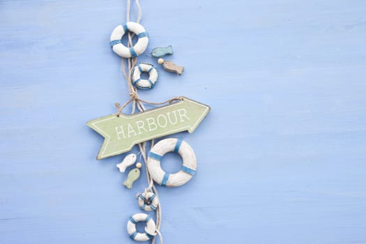 Decorative signpost to the harbour on a blue background made of wood