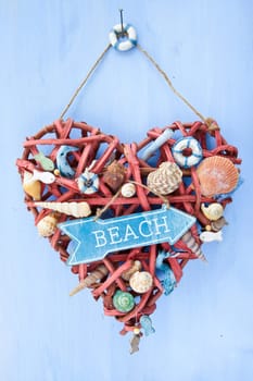 Decorative signpost to the beach on a blue background made of wood