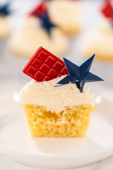 Sliced lemon cupcakes with lemon buttercream frosting, and decorated with patriotic blue chocolate star and red mini chocolate.