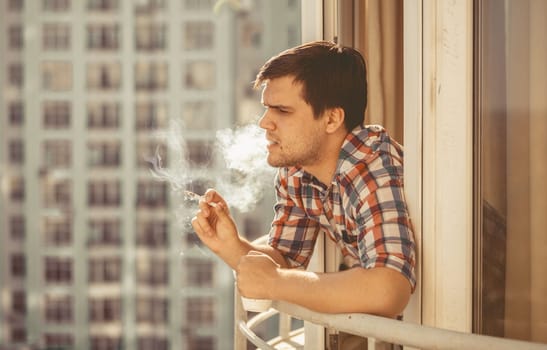 Toned portrait of hipster guy smoking cigarette and drinking coffee