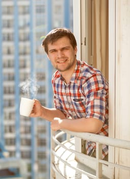 Closeup portrait of man drinking coffee on balcony