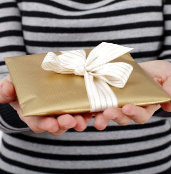 Young woman holding a present in hands