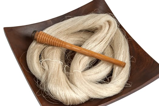 Raw silk yarn and spools of old loom in wooden platter