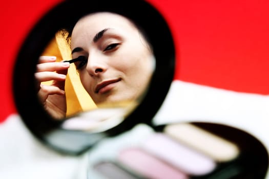 Pretty woman applying make up.