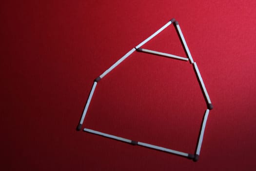 house made of matches isolated on red backround
