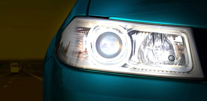 Car on the road. Close-up of the headlight.