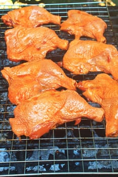 Grilled chicken thigh on the flaming grill