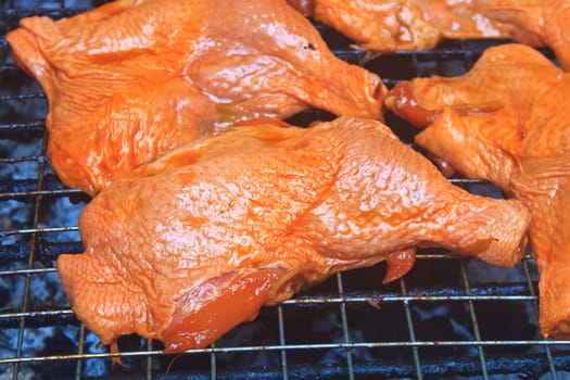 Grilled chicken thigh on the flaming grill