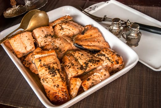 Porcelain dish with grilled salmon fillets closeup
