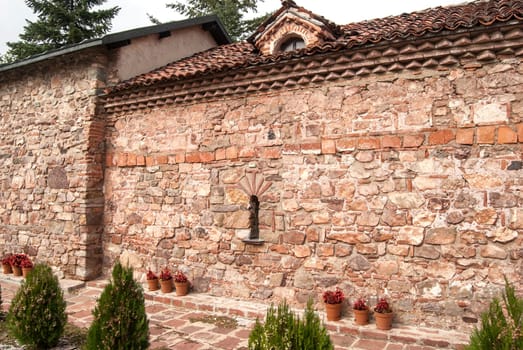 View to stonewall facade of ancient  basilica style orthodox church