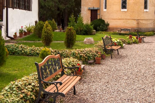 Alley with benches in orthodox monastery courtyard