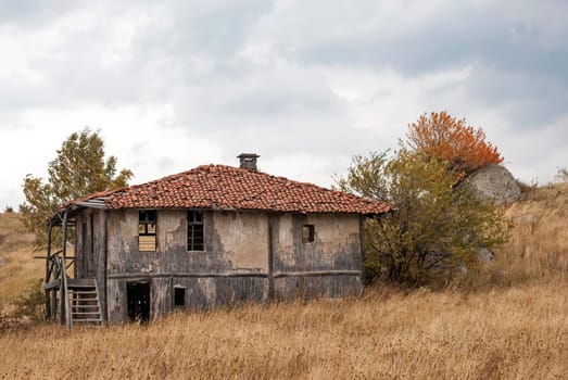 Abandoned house in the mountain on a cloudy autumn day