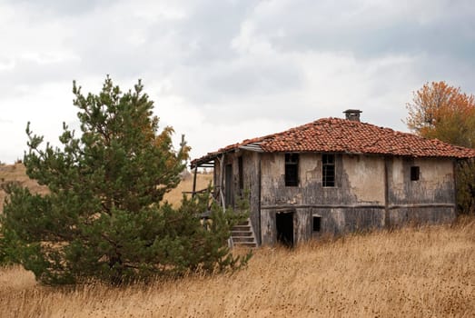 Abandoned house in the mountain on a cloudy autumn day