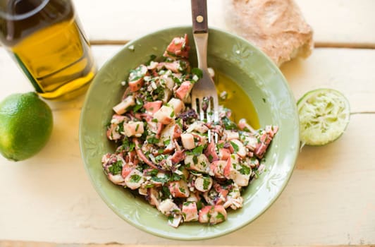 Fresh octopus salad with garlic, parsley, lime and olive oil
