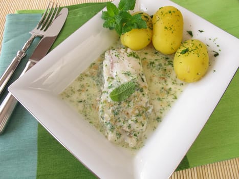 Fish on herb sauce with potatoes