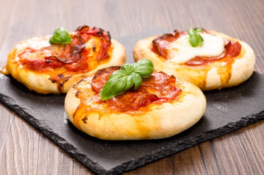 Small pizza with salami and basil