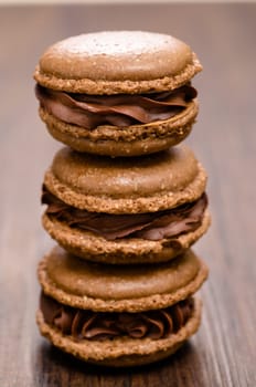 Three brown chocolate macarons on a stack