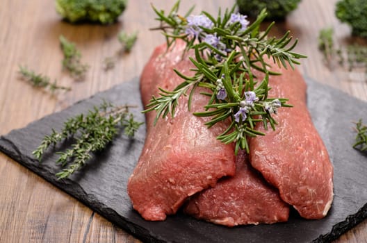 Lamb back raw with rosemary and thyme herbs