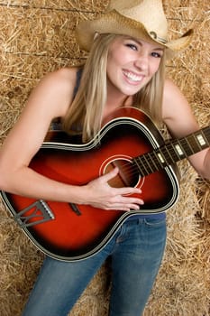 Beautiful cowgirl woman playing guitar
