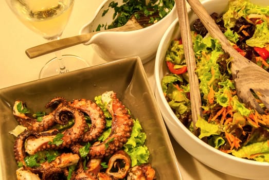 Fried octopus with olive oil and fresh salad dishes