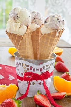 Ice cream in waffles with fresh strawberries and oranges