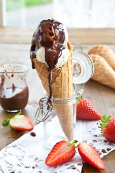 Ice cream in waffle with chocolate sauce and fresh strawberries