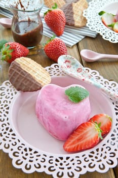 Ice cream in heart shape with fresh strawberries on pink plates