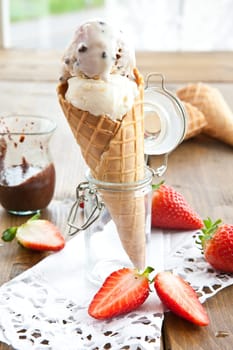 Ice cream in waffle with chocolate sauce and fresh strawberries