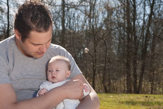 Young father is having some nice time with his baby on a sunny day