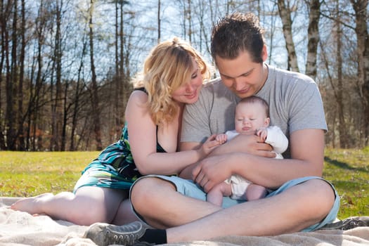Young family is having  nice time with their baby on a sunny day