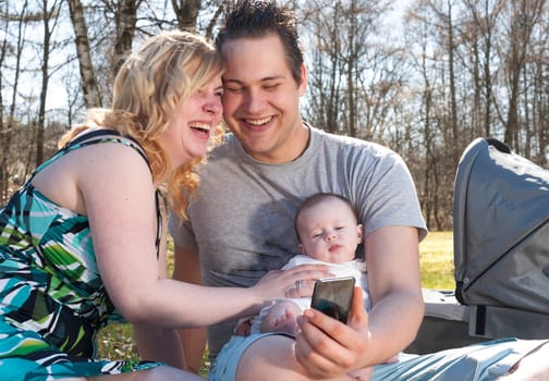 Young family is taking a selfie picture with their smartphone