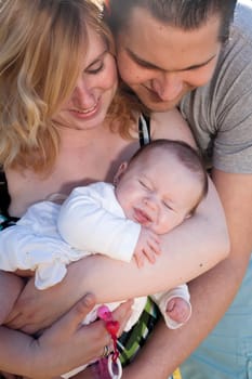 Young family is having  nice time with their baby on a sunny day