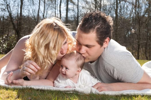 Young family is having  nice time with their baby on a sunny day