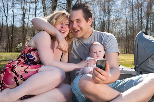 Young family is taking a selfie picture with their smartphone