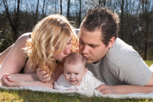 Young family is having  nice time with their baby on a sunny day