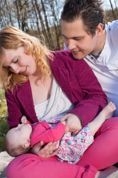 Young family is having  nice time with their baby on a sunny day