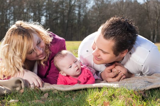 Young family is having  nice time with their baby on a sunny day