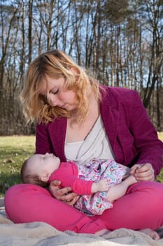 Young mother is having some nice time with her baby on a sunny day