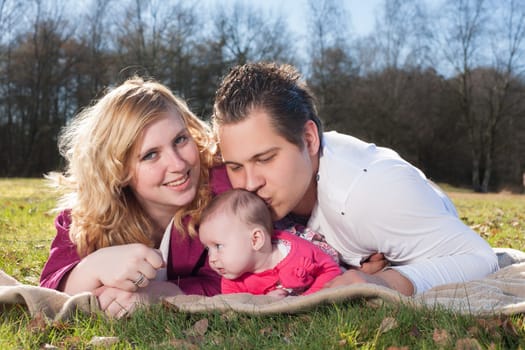 Young family is having  nice time with their baby on a sunny day