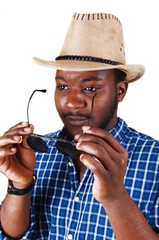 A serious looking black man in a portrait picture with a cowboy hat, holding.his sunglasses, isolated for white background..