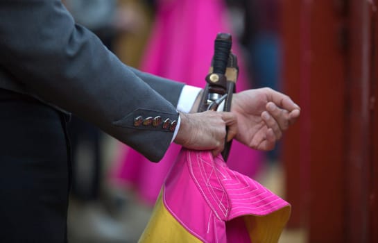 The bullfighter prepares his daggers behind the barrier of the bullring