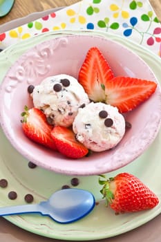 Ice cream with strawberries and chocolate in pink scounda