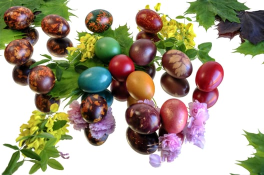 Many beautiful and colorful eggs on mirror floor and clean white background.
