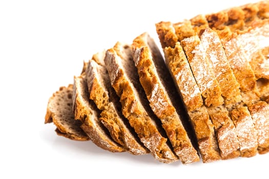 Freshly baked sliced loaf of rye bread viewed from a high angle close up on white with copyspace