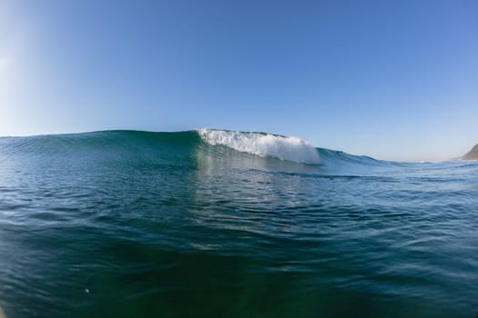 Ocean wave crashing water power energy on shallow reefs nearby beach coastline