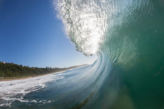 Ocean wave crashing water power energy on shallow reefs nearby beach coastline