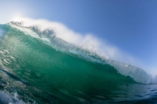 Ocean wave crashing water power energy on shallow reefs nearby beach coastline