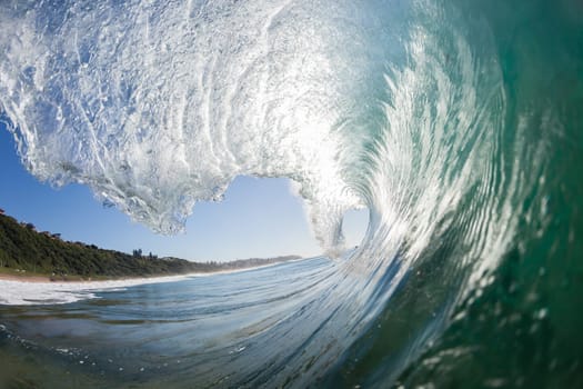 Ocean wave crashing water power energy on shallow reefs nearby beach coastline