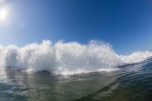 Ocean wave crashing white water power energy on shallow reefs nearby beach coastline